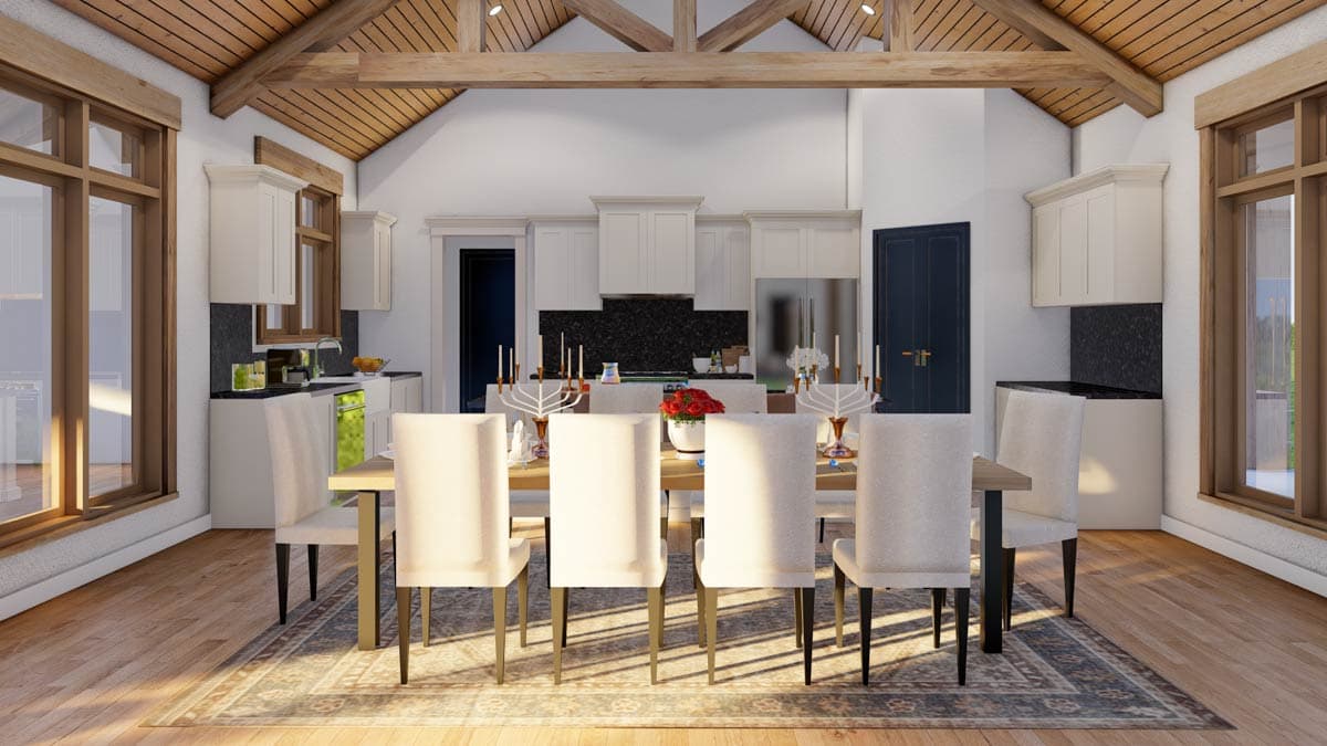 Dining area with vaulted ceiling, exposed beams, wooden floors, and adjacent kitchen with white cabinets and granite countertops.