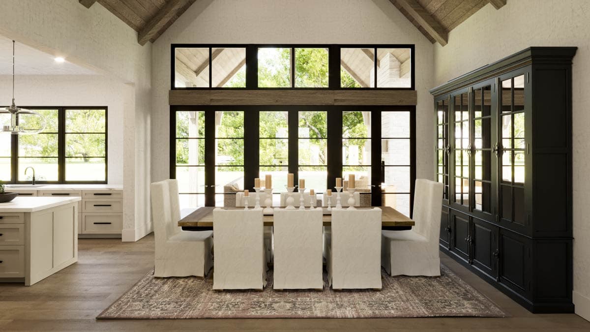 Elegant dining room with large windows, a long wooden table, and a black cabinet.