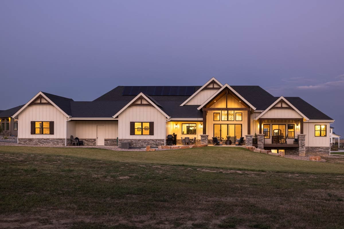 House plan exterior: Modern Farmhouse style, two stories, with gabled dormers, exposed beams, and covered porches.