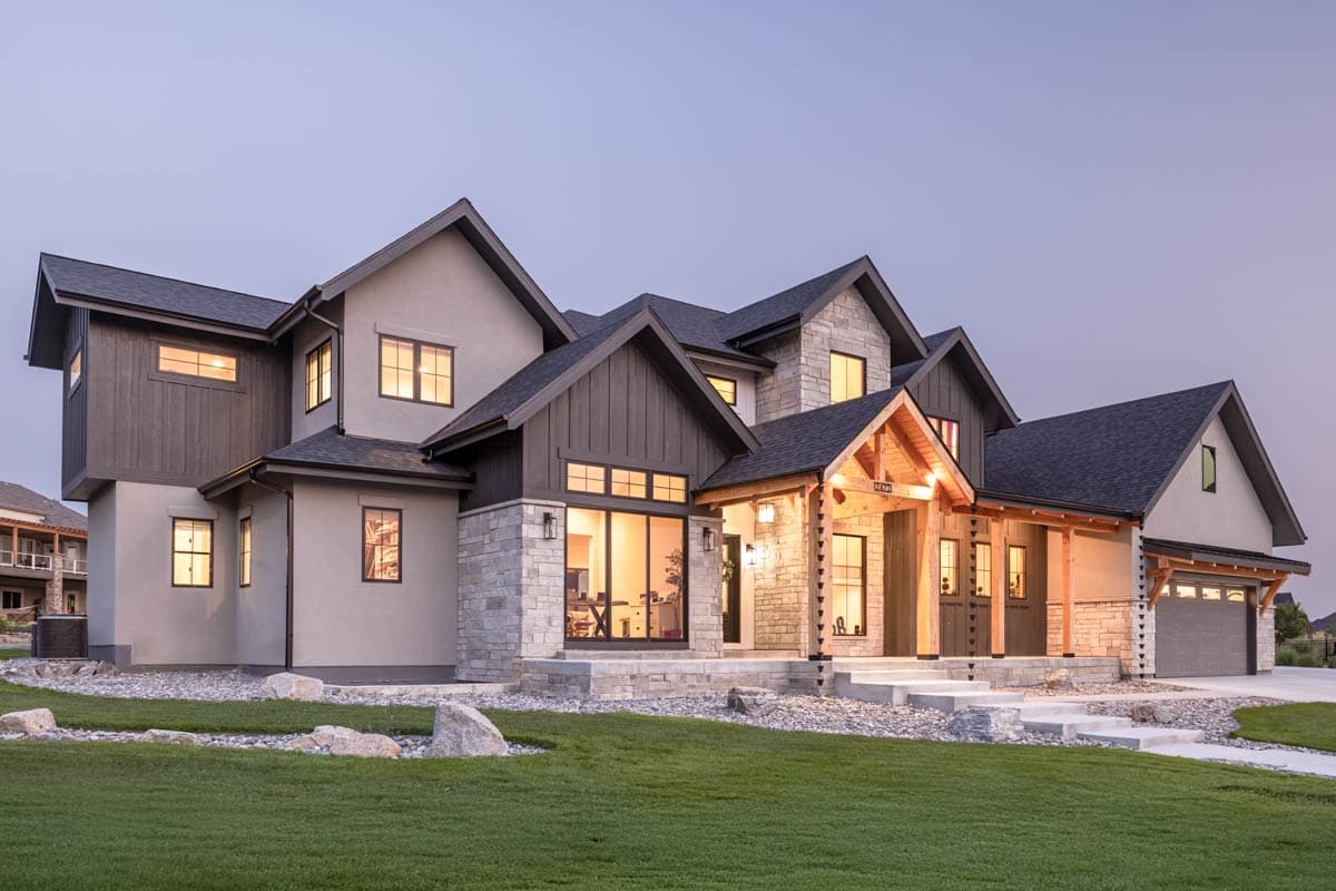House plan exterior: Modern farmhouse with stone and wood accents, multiple gables, prominent covered entry, and attached garage.