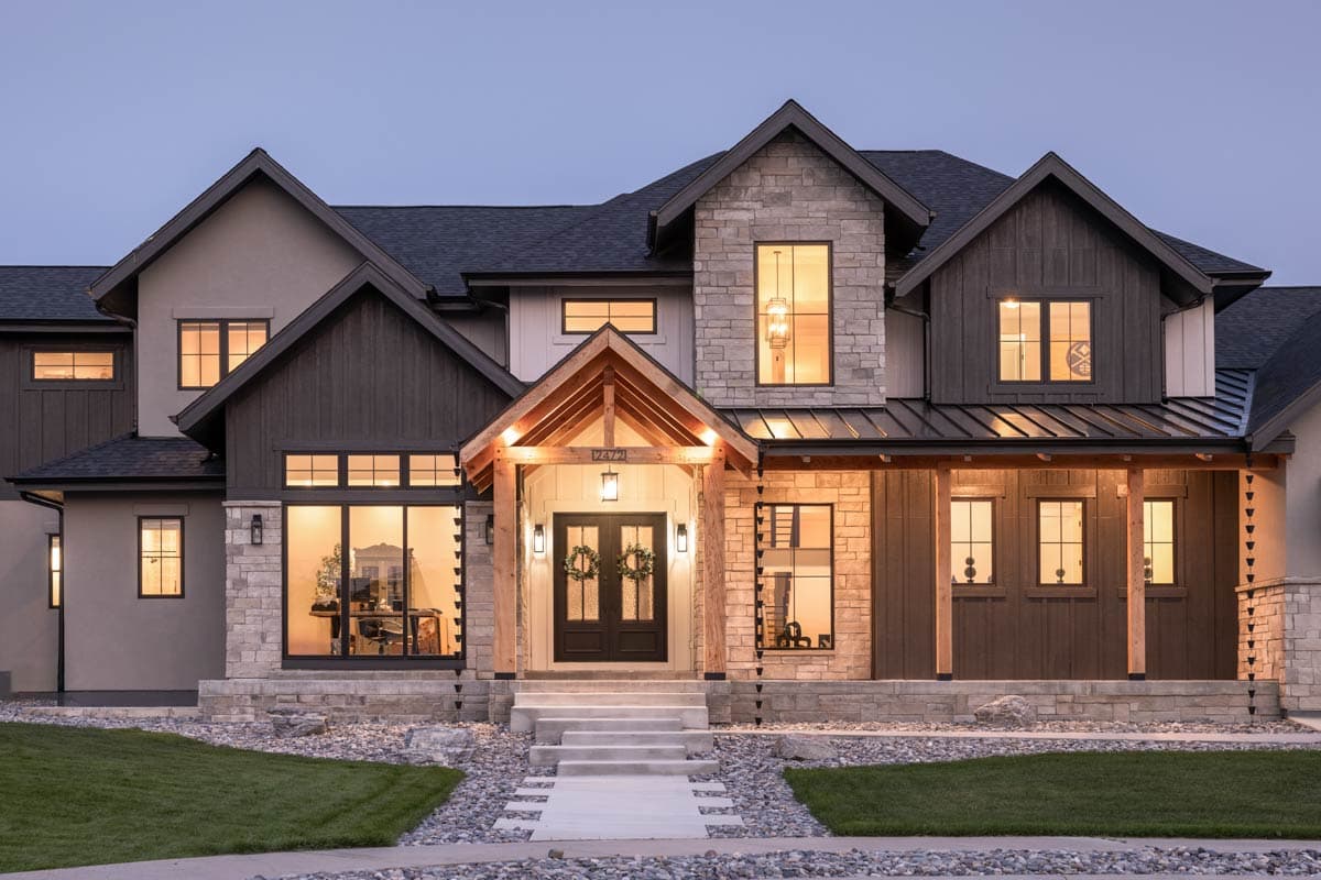 House plan exterior: Modern farmhouse style, two stories, stone and wood facade, gabled rooflines, covered porch with exposed beams.