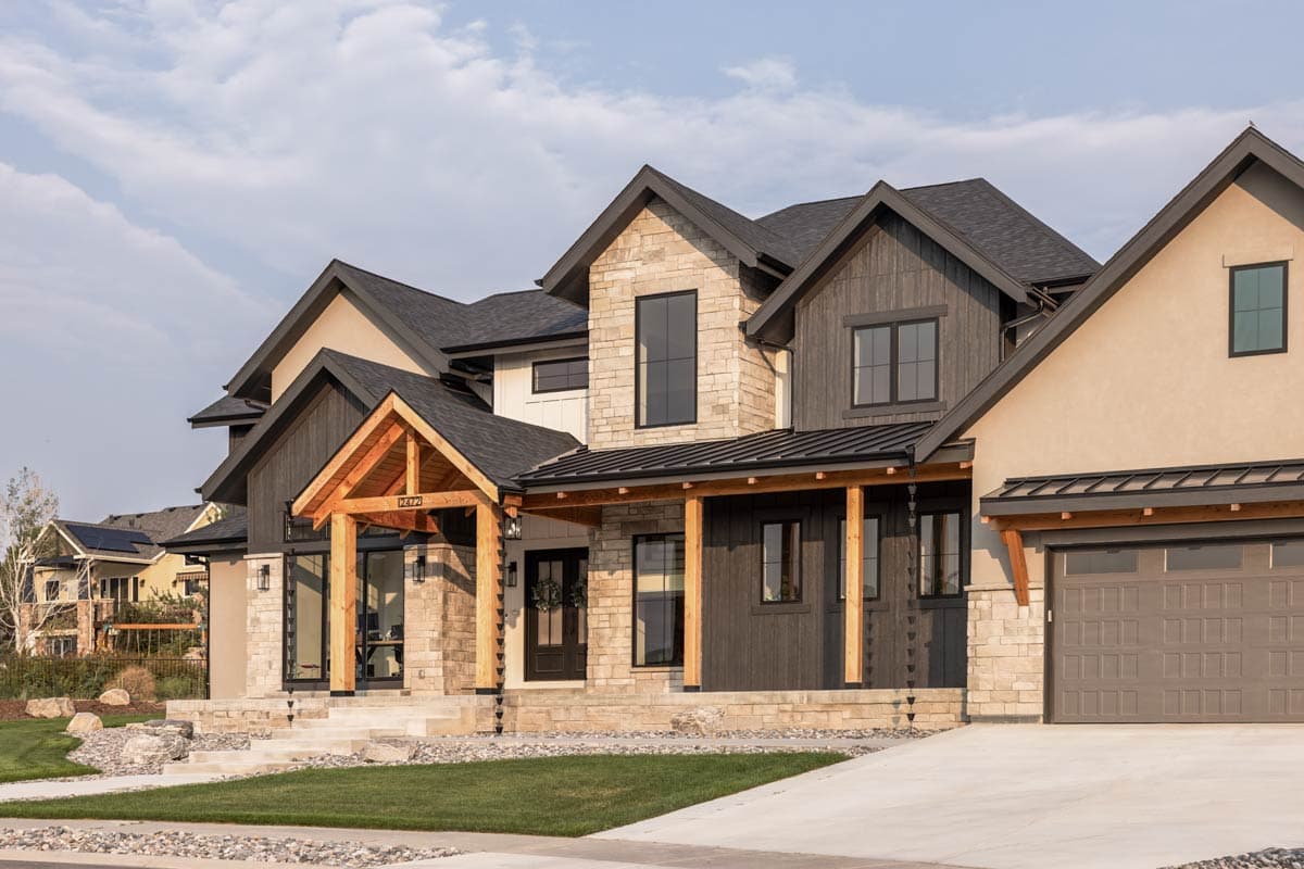 Two-story Modern Farmhouse exterior plan with stone and dark wood siding, exposed wood beams, and a covered front porch.