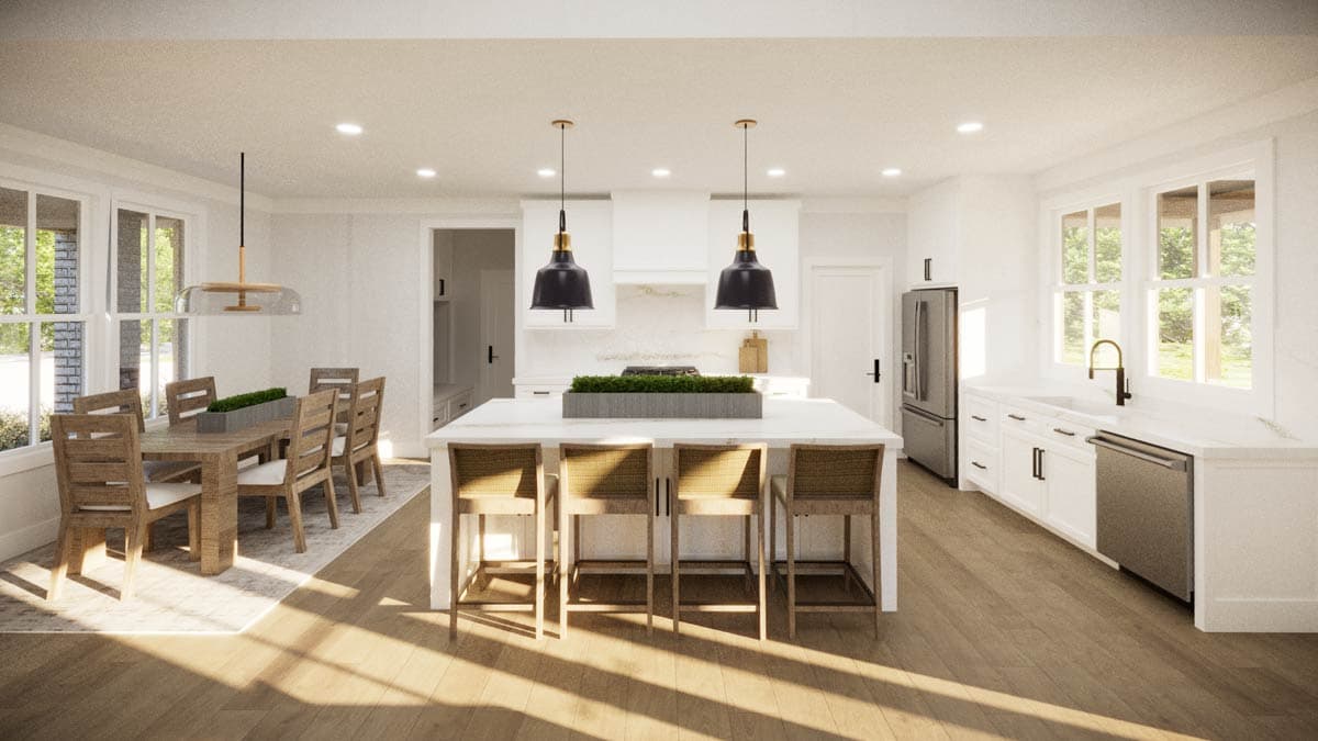 Bright, modern kitchen with island and dining table. Features pendant lights, white cabinets, and wood flooring.