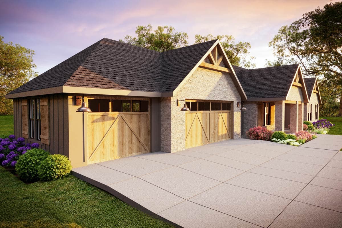 A craftsman-style home exterior with a stone facade, wooden garage doors, and lush landscaping, set against a sunset sky.
