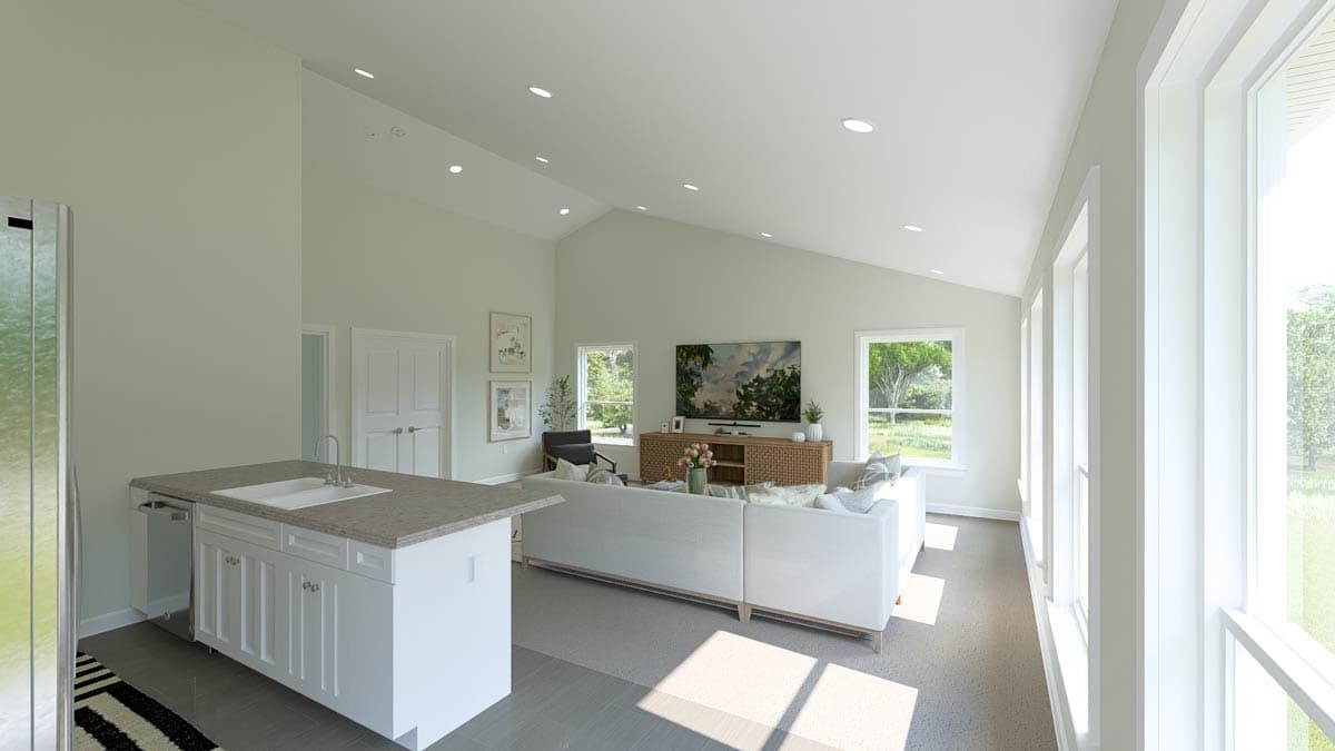 Open-concept living area with vaulted ceiling, kitchen island with sink, and large windows.