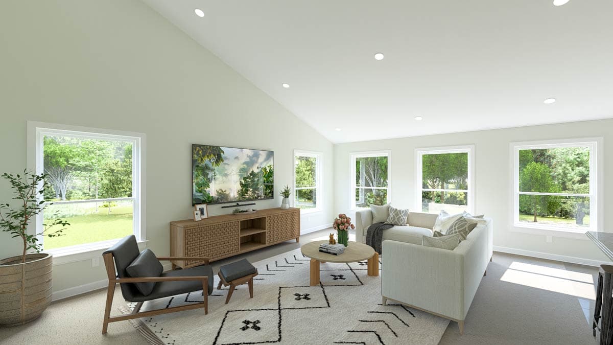 Living room with vaulted ceiling, large windows, a TV console, and sofas.