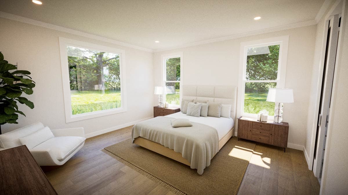 Bright, airy bedroom with a bed, windows overlooking a green lawn, and a modern white chair.