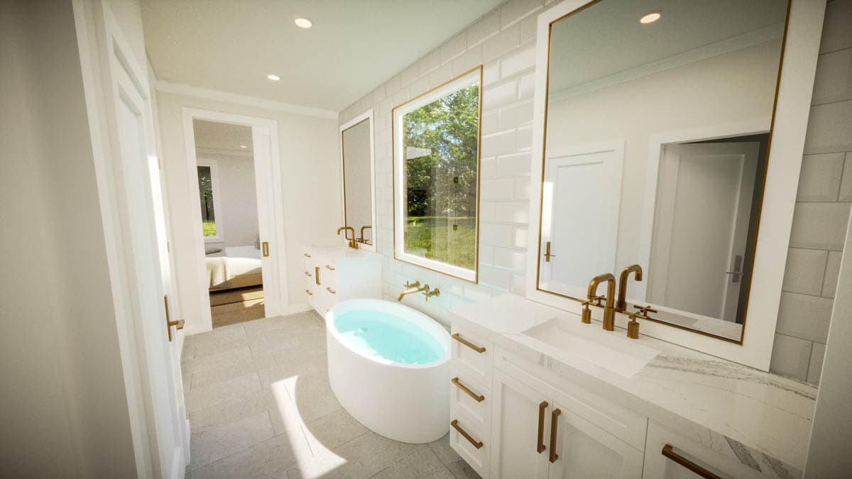 Luxurious bathroom with a white oval bathtub, gold fixtures, large mirrors and a view of the outdoors.