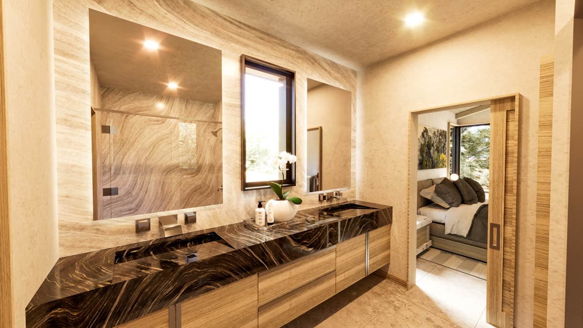 Luxurious bathroom with dark stone countertop, wooden cabinets, large mirrors, and view into bedroom through a sliding door.