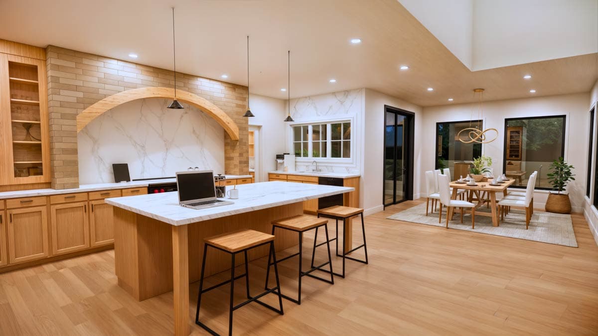 Open-concept kitchen and dining area with large island, wooden cabinetry, vaulted ceiling, and dining table with chairs.
