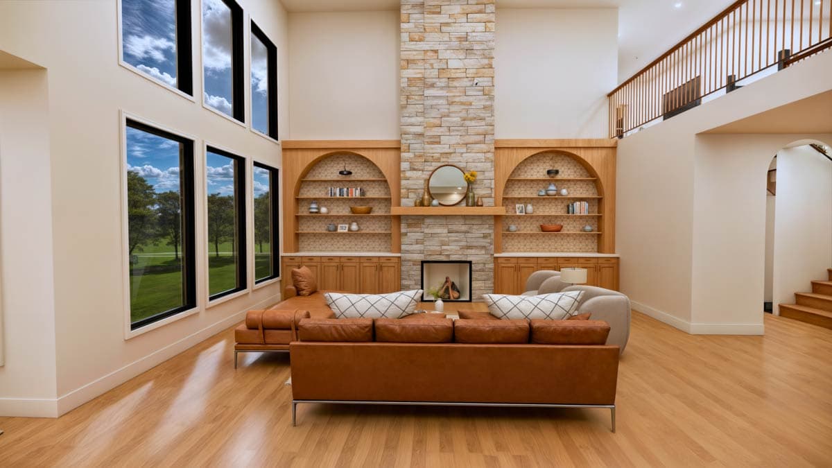 Great room with vaulted ceiling, stone fireplace, built-in shelving, and large windows.