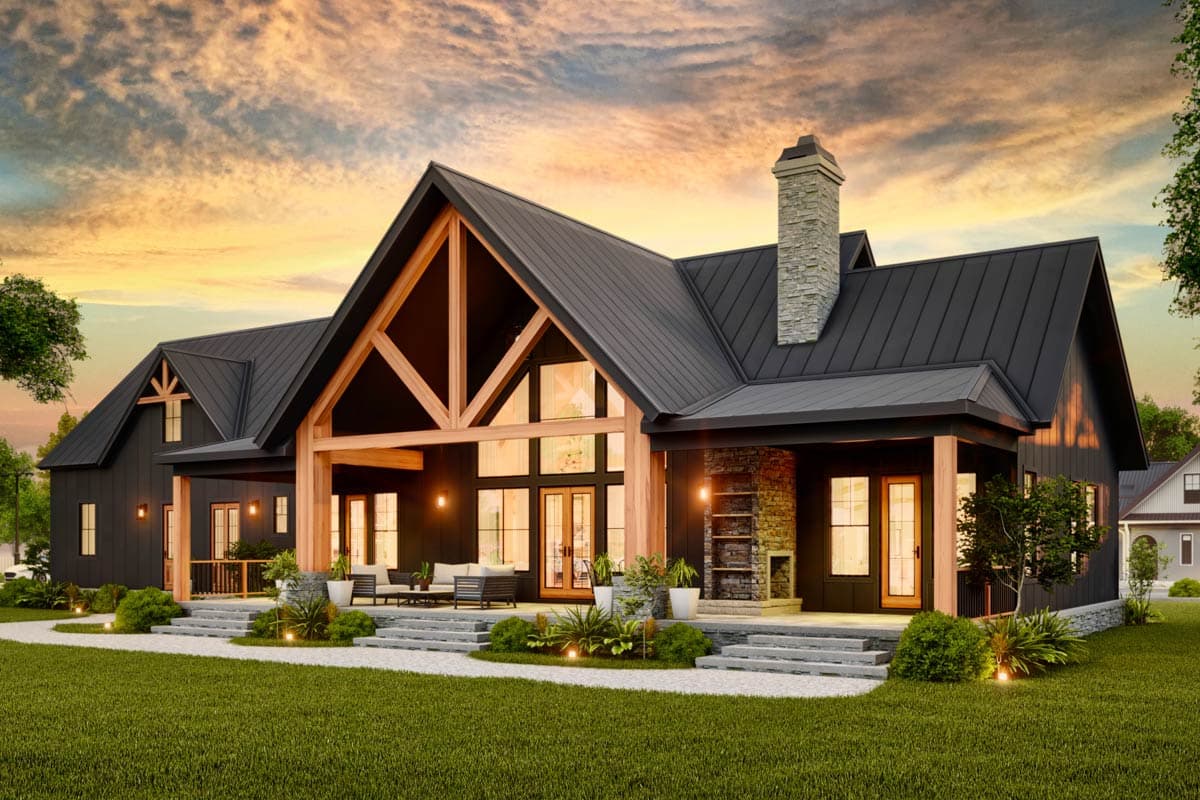 Modern Farmhouse house plan exterior with a dark metal roof, large gabled dormer, exposed timber framing, and stone chimney.