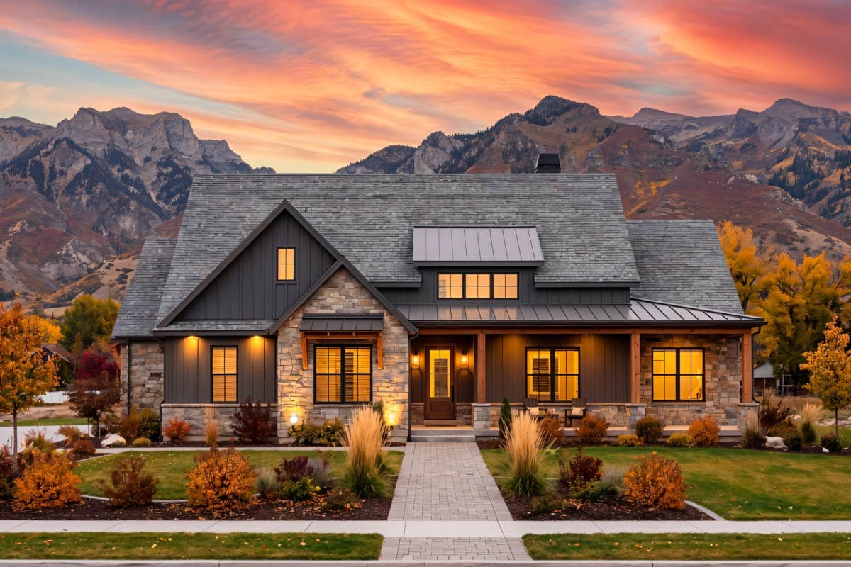 House plan exterior. Modern Farmhouse style, two stories, with stone accents, gables, dormers, and a wraparound porch.