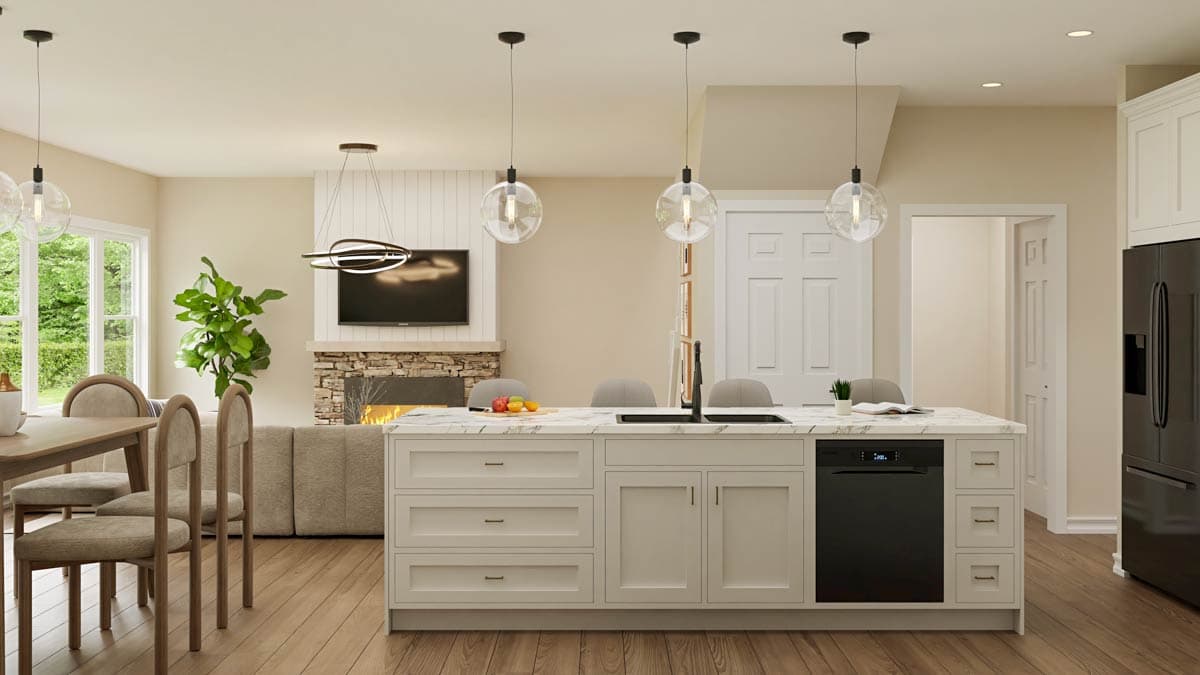 A modern, open-plan kitchen with a large island and pendant lights. A living area with a fireplace and television is visible in the background.