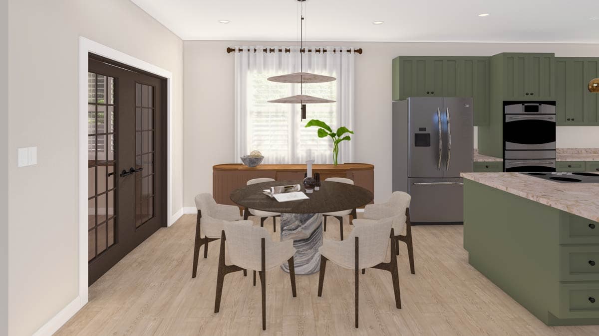 Open concept dining area with round table and chairs adjacent to kitchen with island, double ovens, and green cabinetry.