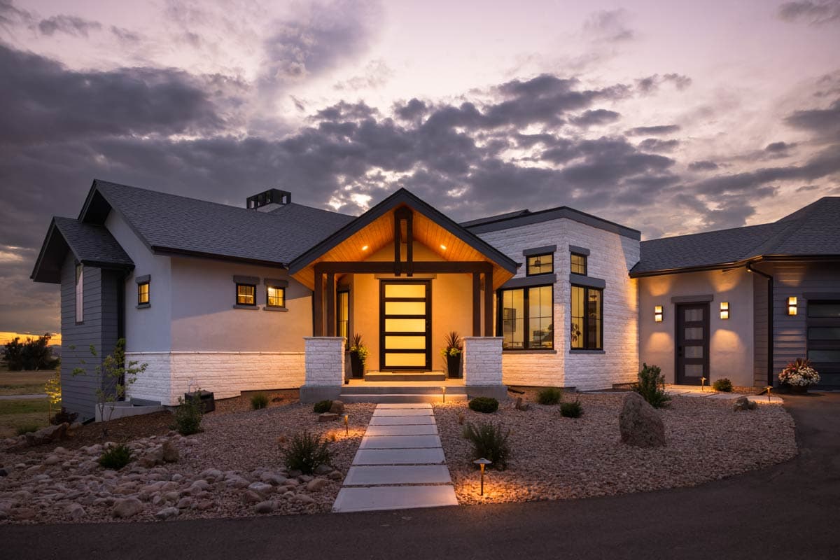 House plan exterior. Modern style with a gabled entry, exposed beams, and a mix of materials on the facade and the roof.
