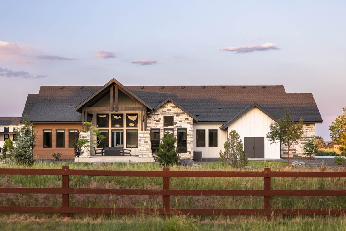 Modern ranch house plan exterior with stone and wood accents, large gable, and multi-pane windows.