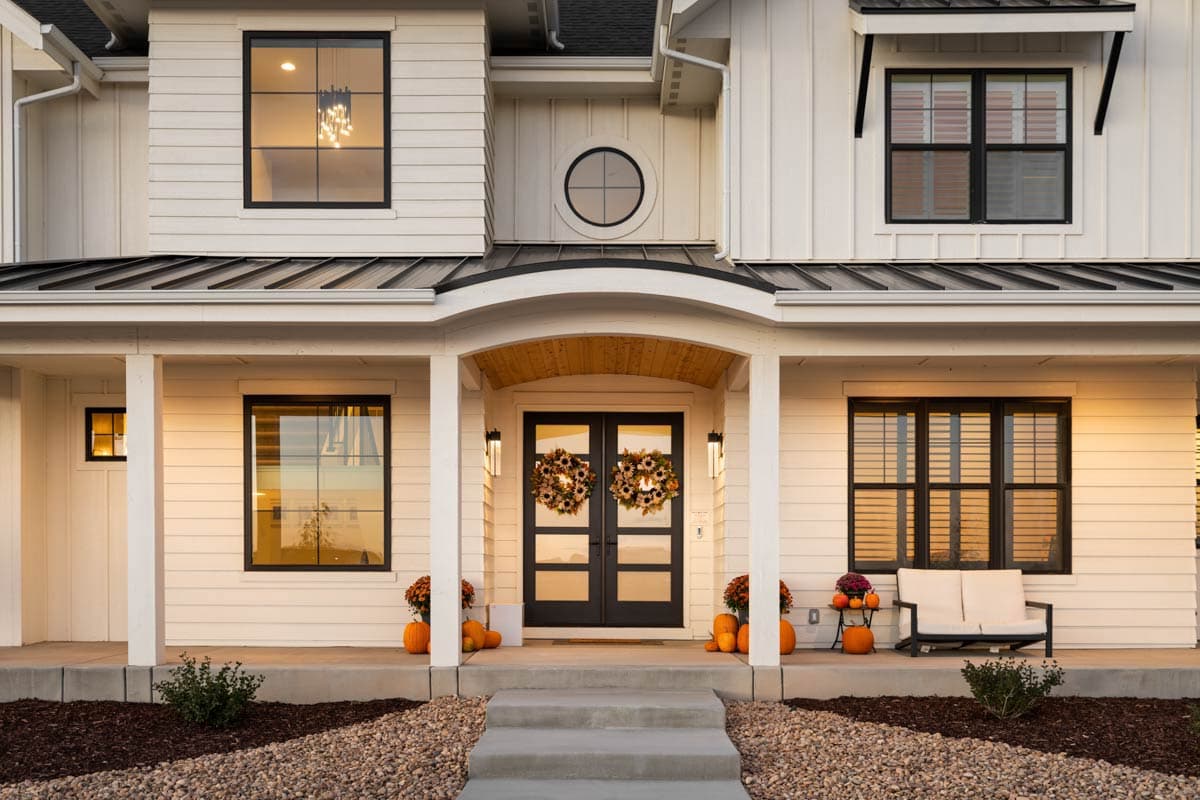 House plan exterior showing a modern farmhouse style with a covered porch, metal roof, and multiple windows.
