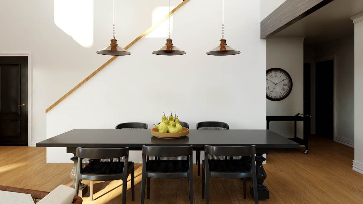 Dining area with dark rectangular table, black chairs, three pendant lights, and staircase with wood railing.