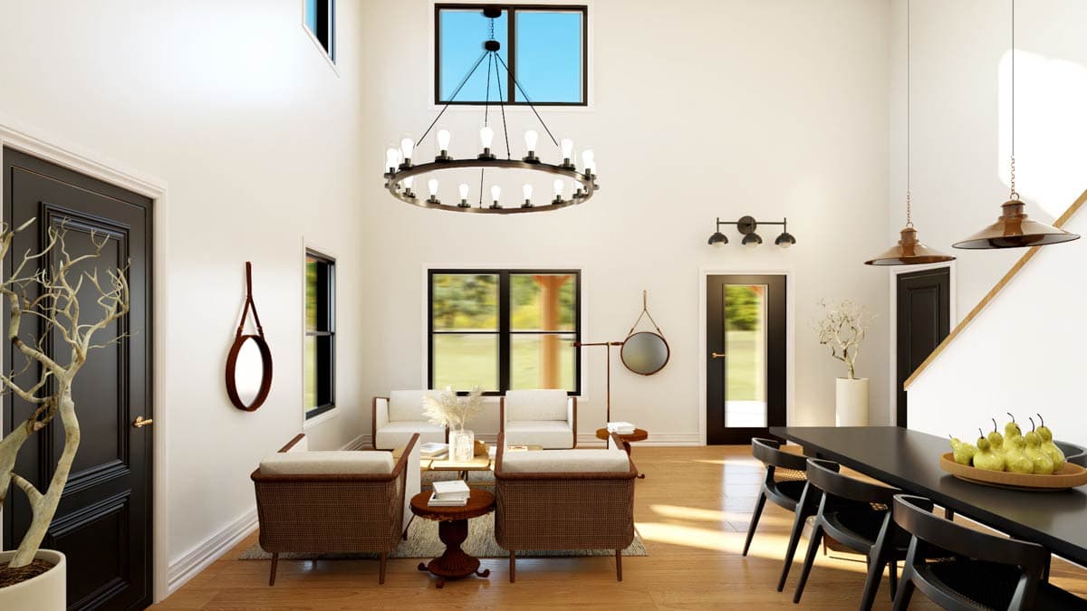 Interior view of a great room with vaulted ceiling, large circular chandelier, fireplace, and dining area.