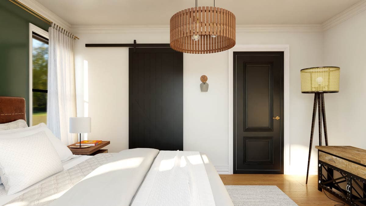 Bedroom with king bed, black barn door, white curtains, and wood pendant light.