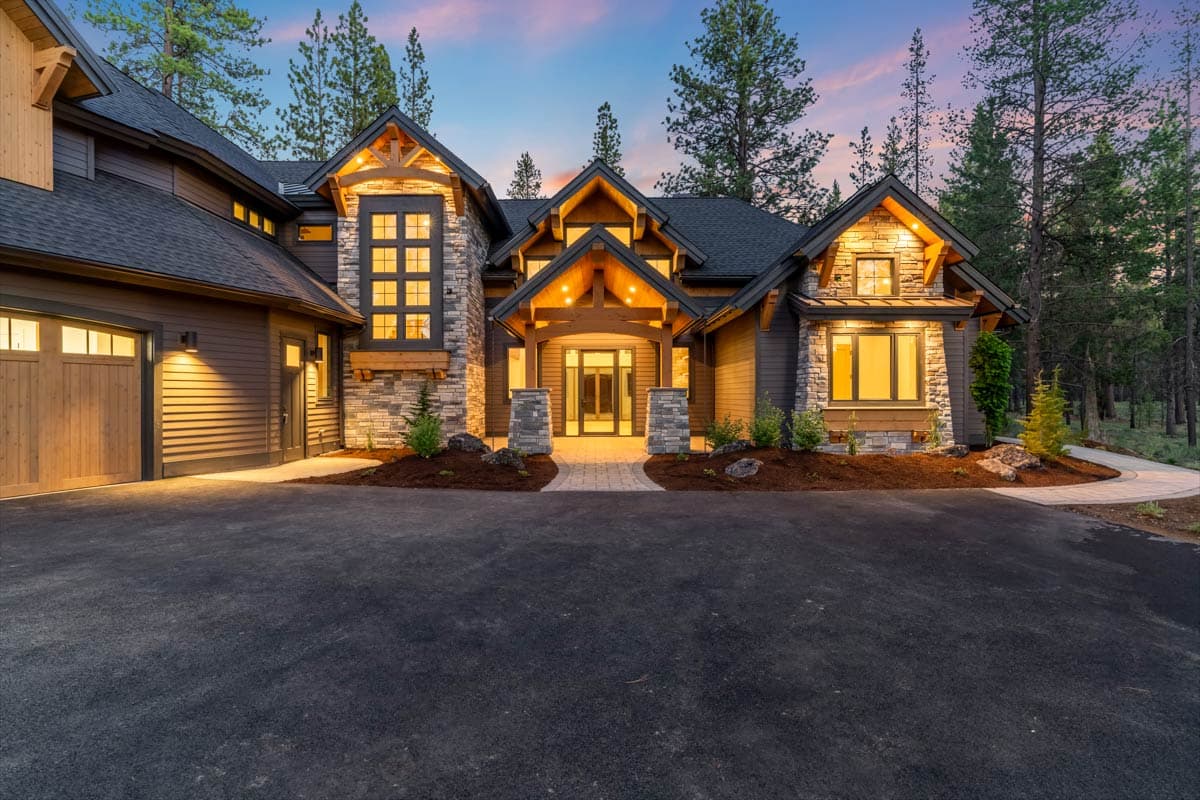 House plan exterior with stone and wood siding, multiple gables, large windows, and attached garage.