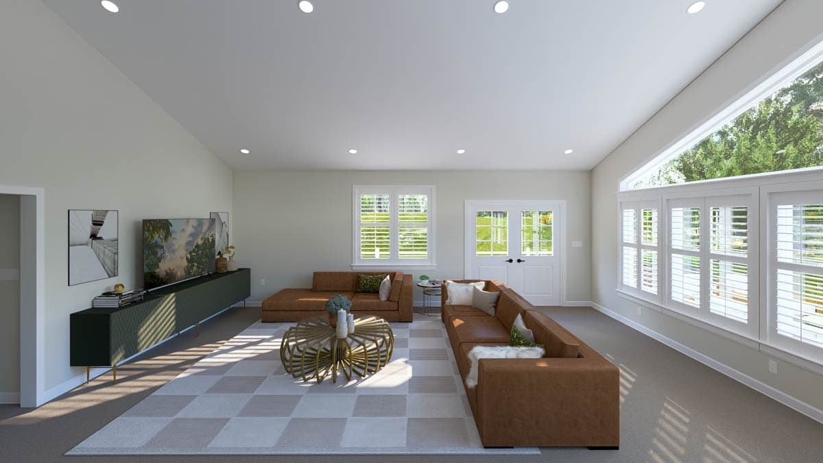 Living room with vaulted ceiling, large sectional sofa, coffee table, and windows.