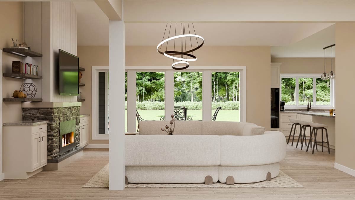 Open concept living area with stone fireplace, sectional sofa, and kitchen island with bar seating.