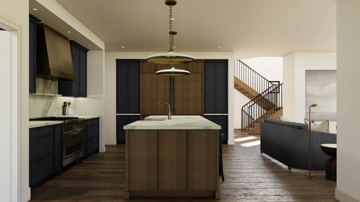 Open concept kitchen with island, dark blue cabinets, brass range hood, and wood staircase leading to upper level.