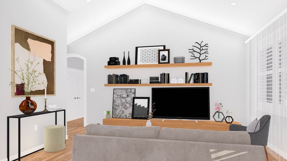 Great room with vaulted ceiling, entertainment center with shelves, and sofa.