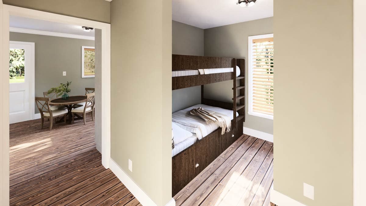 Interior shot showcasing a bunk bed in a small room. The room connects to a dining area with a round table and chairs, visible through a doorway.