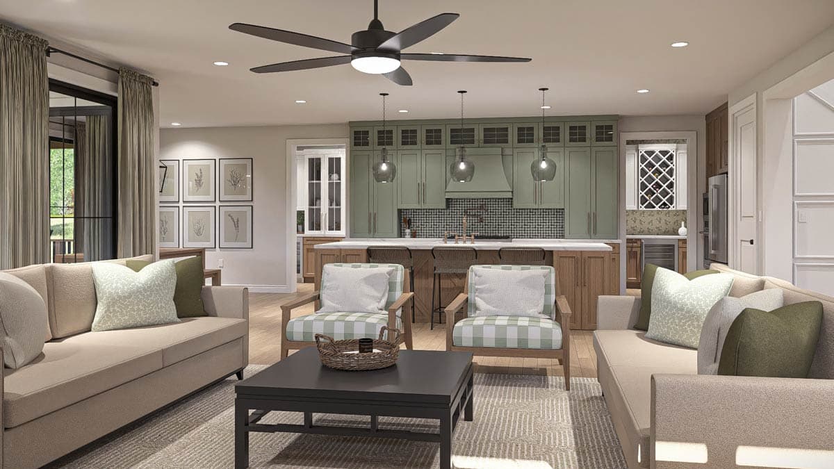 Open concept living space with sectional sofas, armchairs, island kitchen with green cabinetry, and dining area.