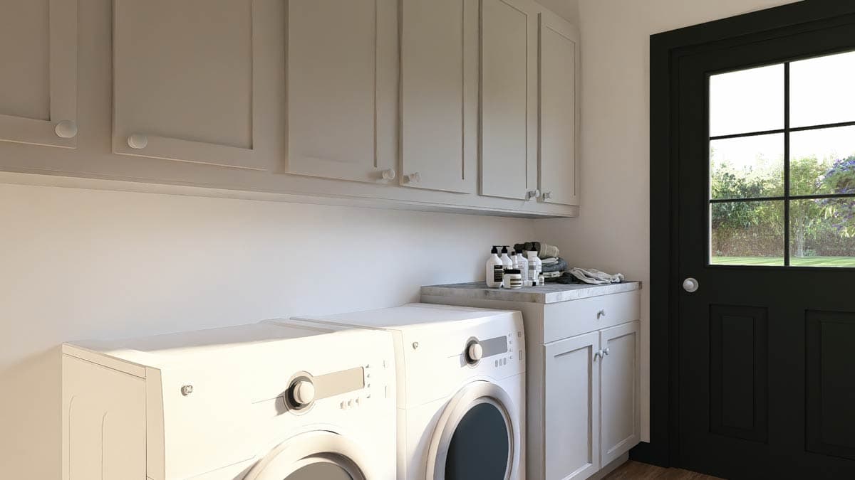 Laundry room interior with stacked washer and dryer, upper cabinets, and black exterior door with window panes.
