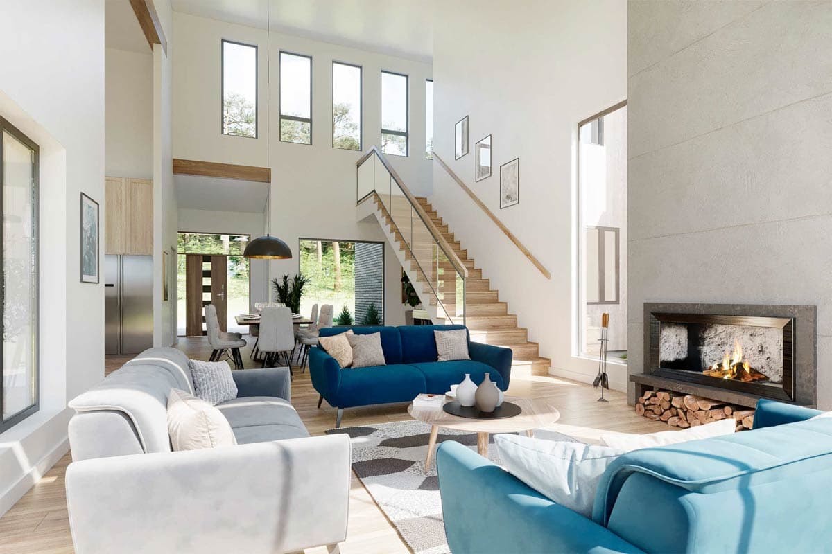 Modern living room with blue sofas, fireplace, and staircase. Bright, open space with high ceilings and natural light.