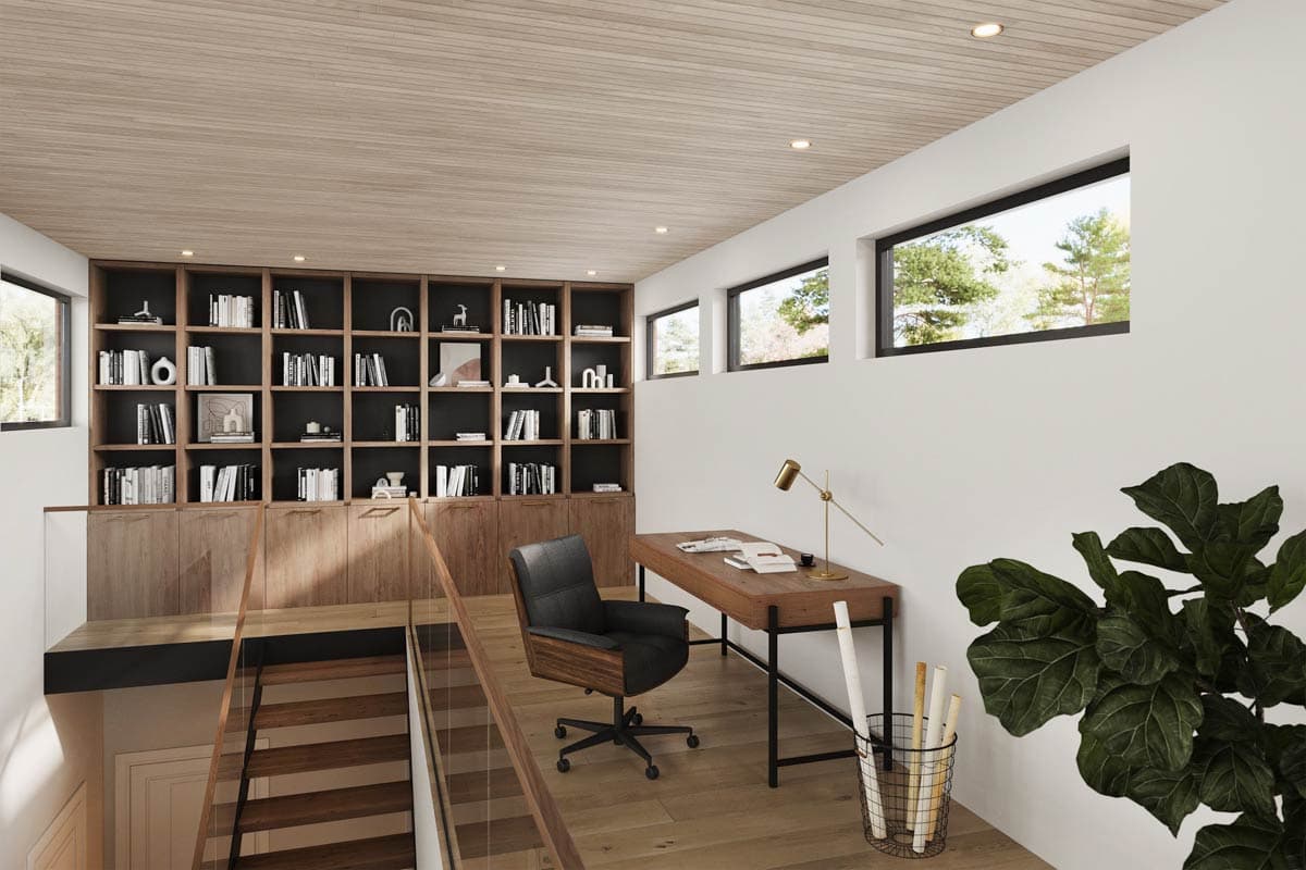 Home office with floor-to-ceiling bookshelves, a desk with chair, and horizontal windows with natural light.