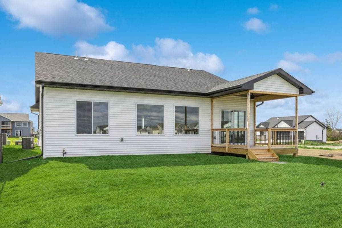 House plan exterior: Modern Ranch style, single-story, white siding, large windows, covered porch with wooden deck.