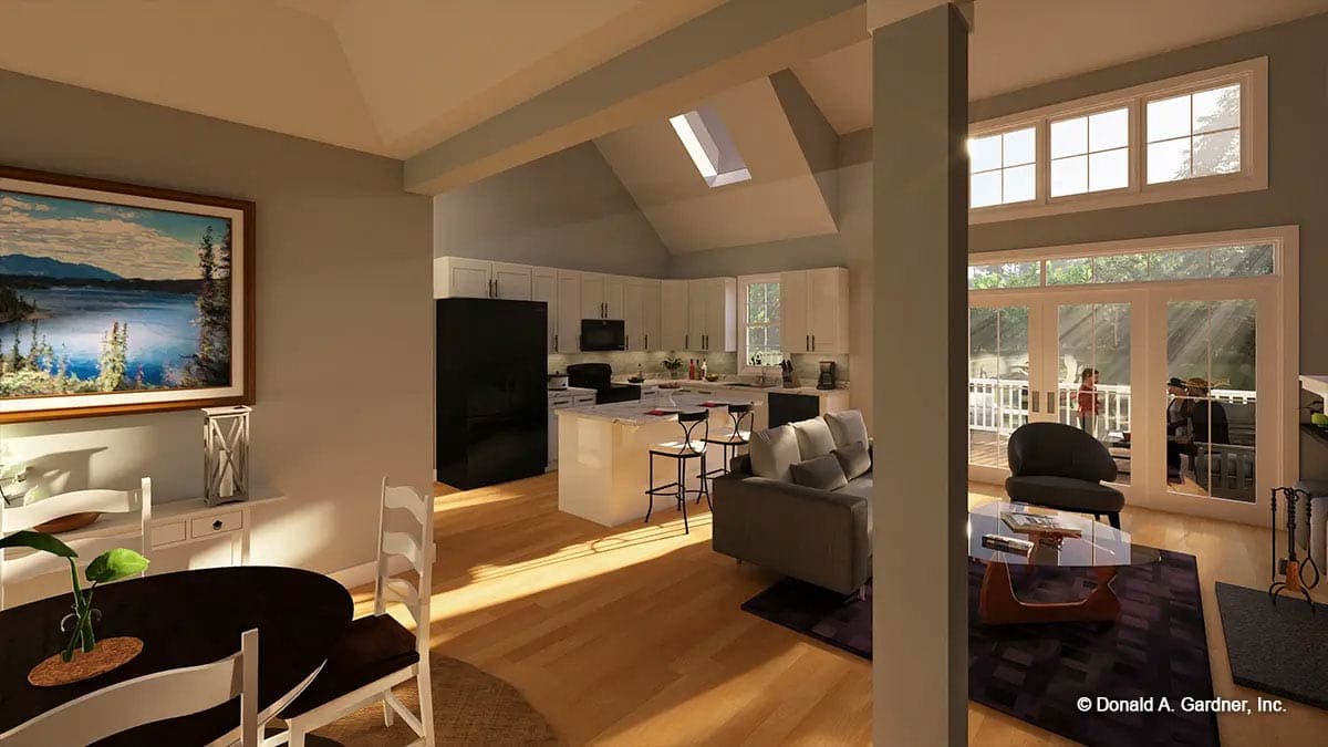 Open concept living space with vaulted ceiling, skylight, kitchen island, large windows, and doors to deck.