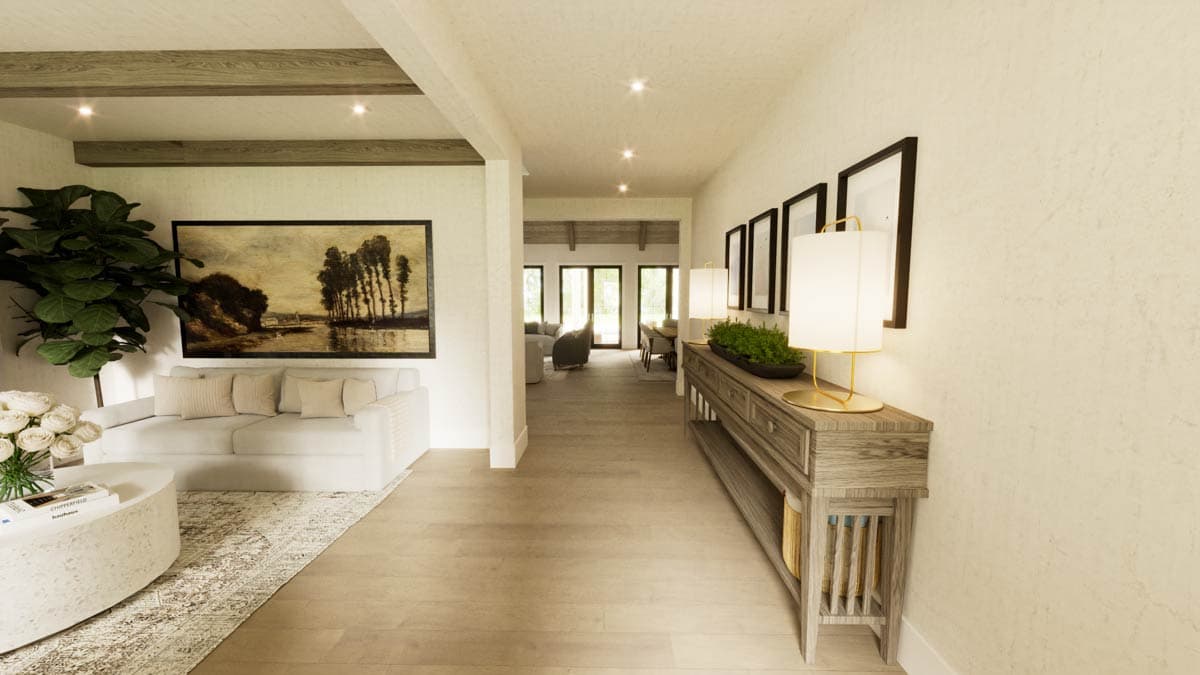 A hallway with light wood floors and white walls. A console table with lamps sits against the wall, with a painting on the left.