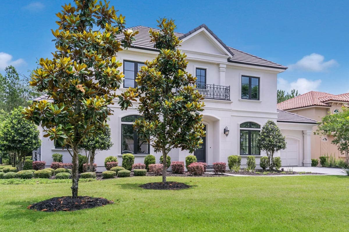 House plan exterior of a two-story Modern Mediterranean style home with a white stucco facade, arched windows, and a tiled roof.