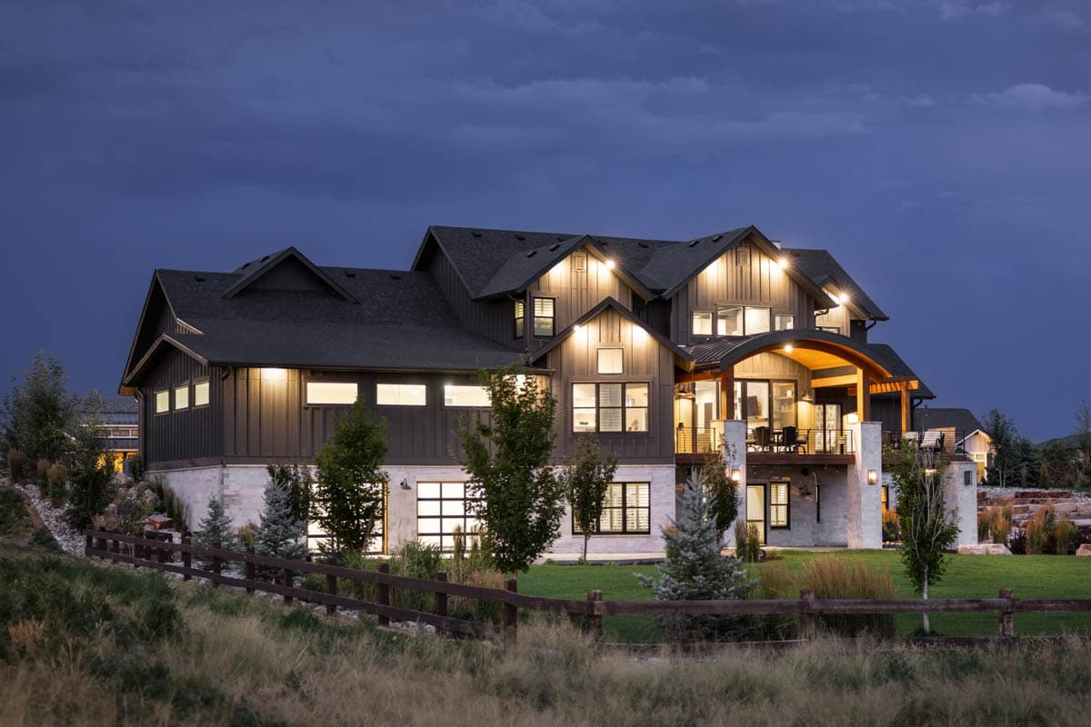 Modern Farmhouse house plan exterior with multiple gables, a curved roof porch, and stone and board-and-batten siding.