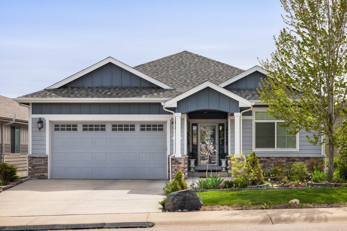 House plan exterior. Craftsman style, one-story home with a gabled roof, front-facing garage, and covered front porch with columns.