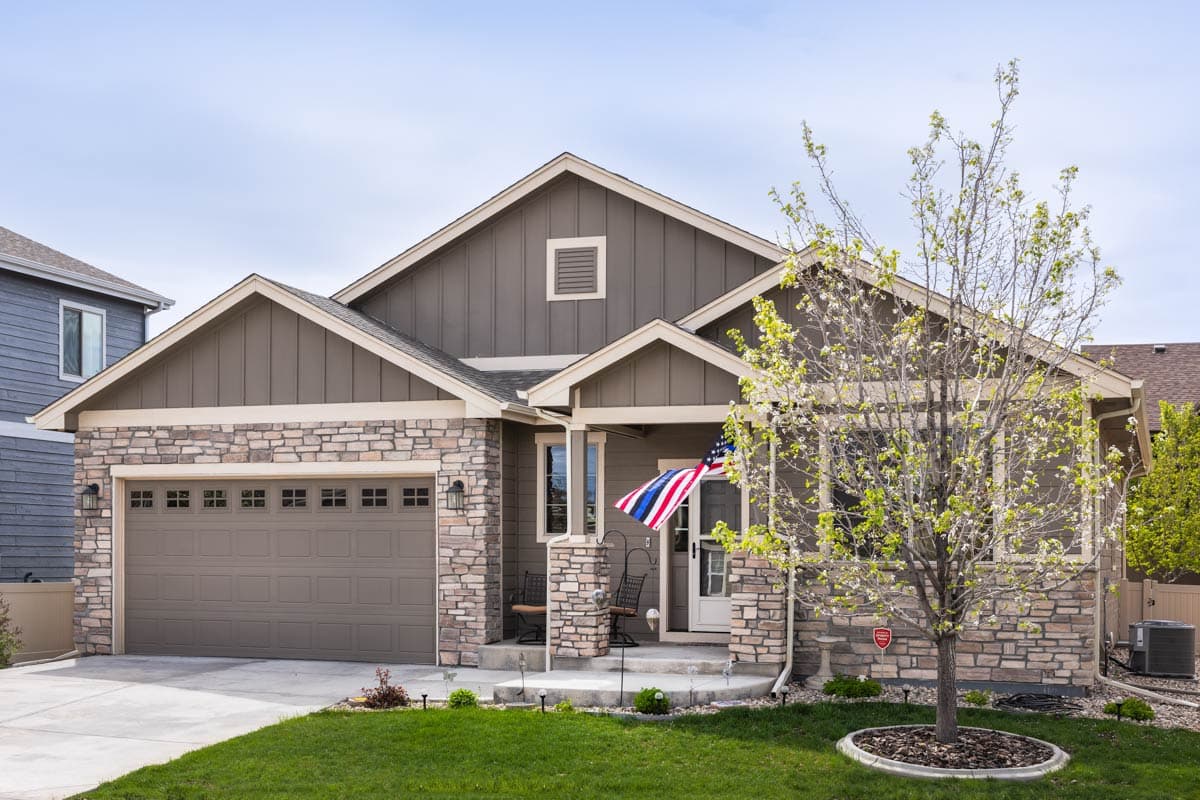Modern Farmhouse style house plan exterior, one story, with stone accents, gable roof, and attached garage.