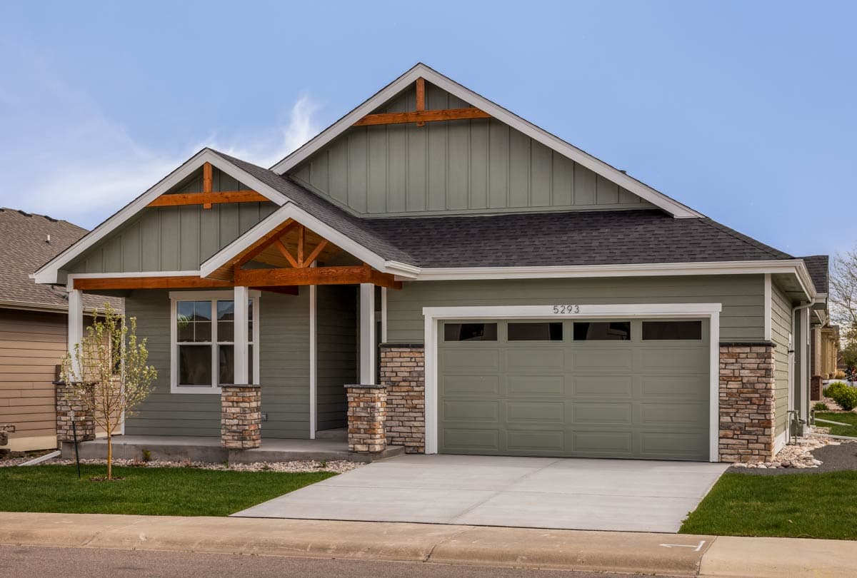 House plan exterior with exposed rafter tails, stone accents, and a two-car garage.
