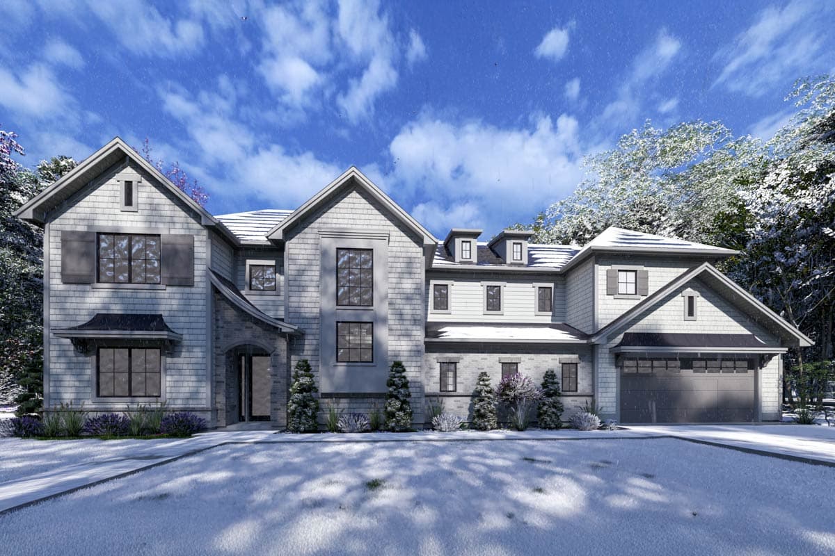 A large two-story house with a snowy yard, trees, and cloudy blue sky. A garage is on the right side of the house.