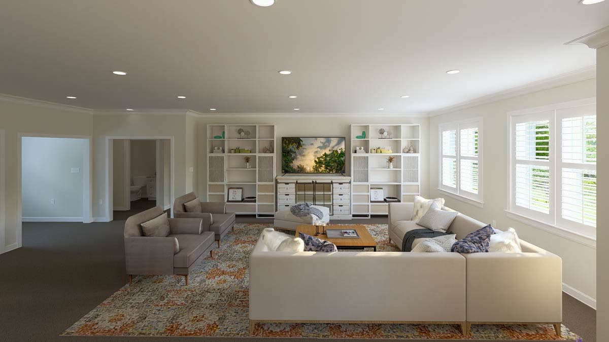 Living room with sectional sofa, built-in bookshelves flanking a media console, and plantation shutters on windows.