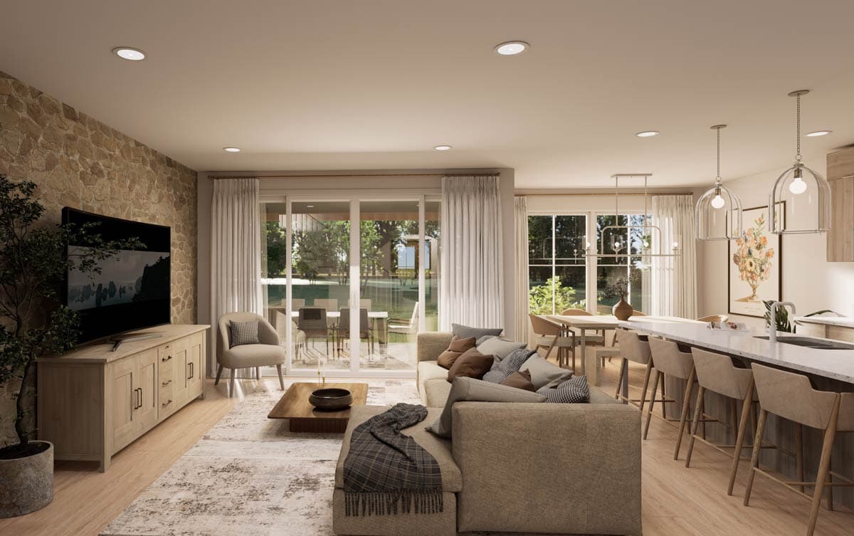 Interior view of a great room with stone accent wall, sectional sofa, dining area, and kitchen island with pendant lights.