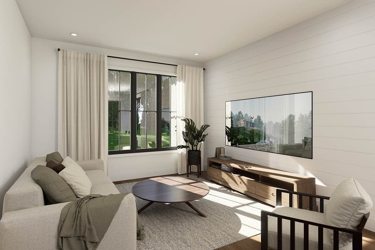 Living room with sectional sofa, round coffee table, accent chair, entertainment console, and large window.