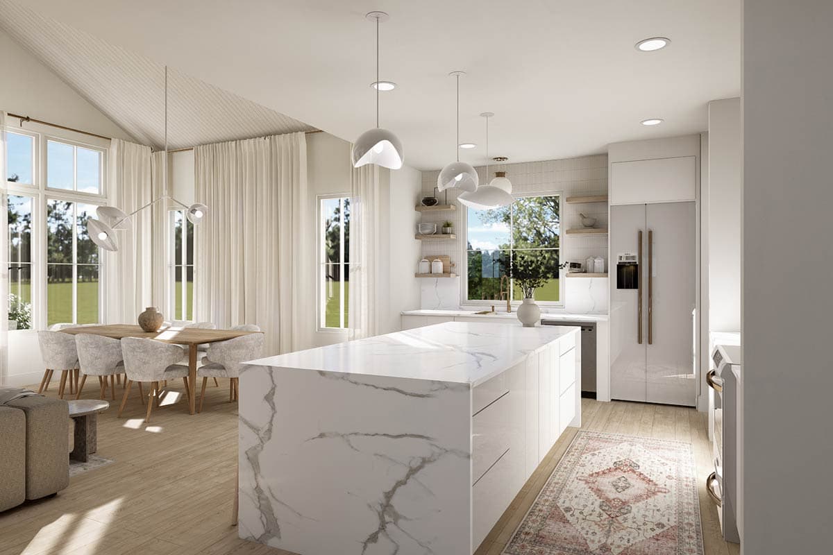 Spacious, modern kitchen with a large marble island. Dining table with white chairs and large windows with natural light in the background.