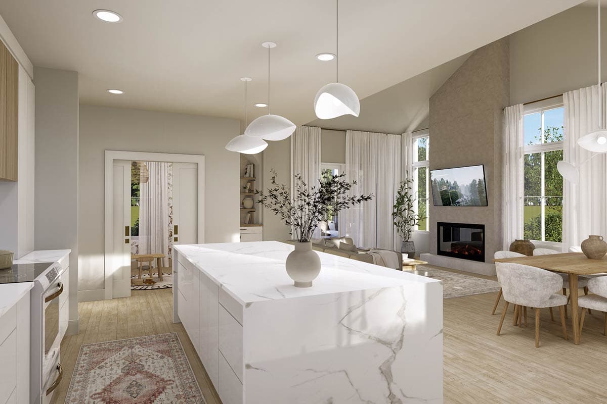 Modern open-plan living space with a large white marble island, fireplace with TV, and dining area, all bathed in natural light.
