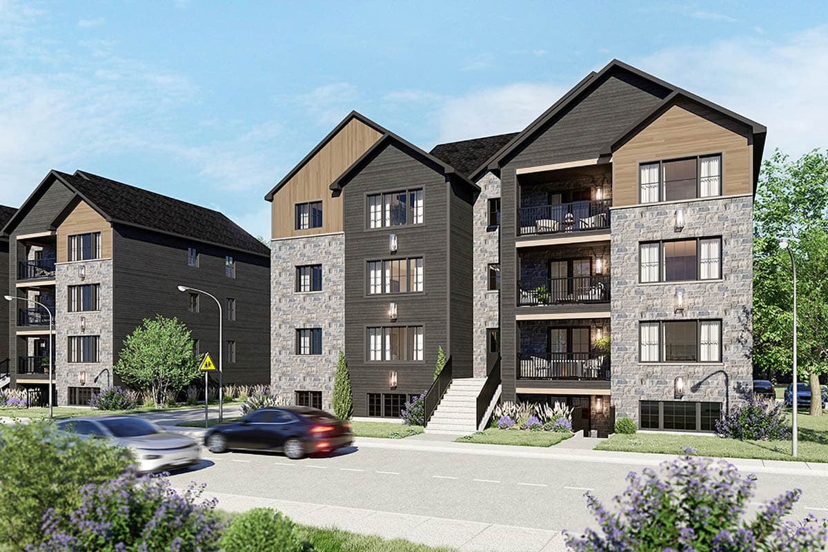Modern residential building exterior with stone and dark wood siding, balconies, and gabled roofs.